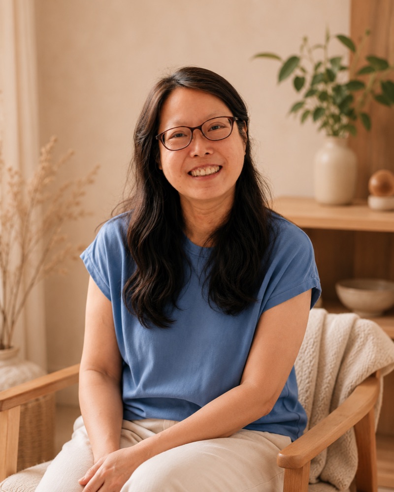 Portrait of Li-Anne Tan seated in a warm, naturally lit room